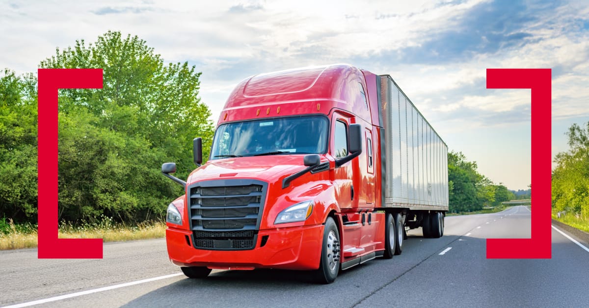 intact-insurance-intelliroute-isaac-telematics-truck Red semi-truck driving on a highway framed by red graphic brackets, illustrating the Intact Insurance IntelliRoute program powered by ISAAC telematics data for usage-based insurance.