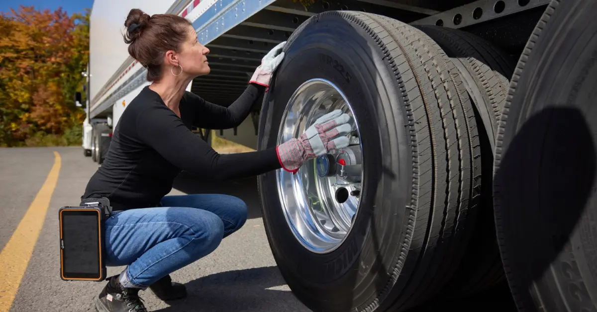 Fleet Professional Conducting Pre-Departure Truck Tire Inspection A vigilant fleet professional conducts a detailed pre-departure tire inspection on a commercial truck, employing ISAAC Instruments technology to ensure safety and compliance.